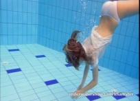 Una chica preciosa desnudándose en una piscina